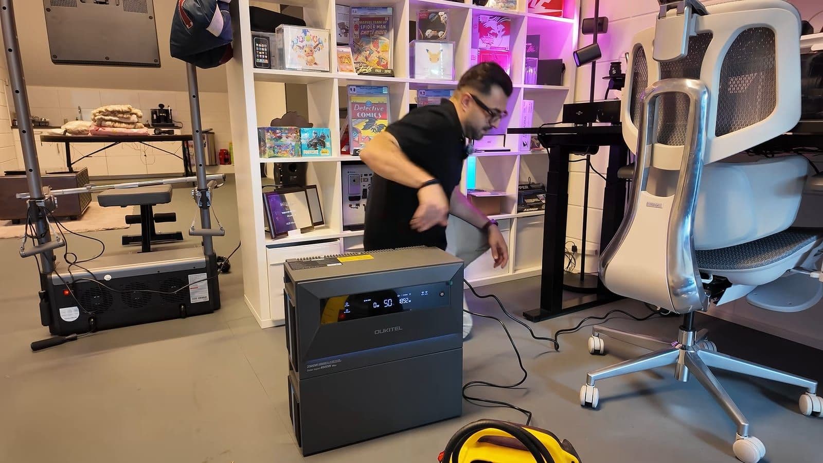 Zino loopt weg van de Oukitel EP2500 met in de voorgrond een gele compressor op de vloer