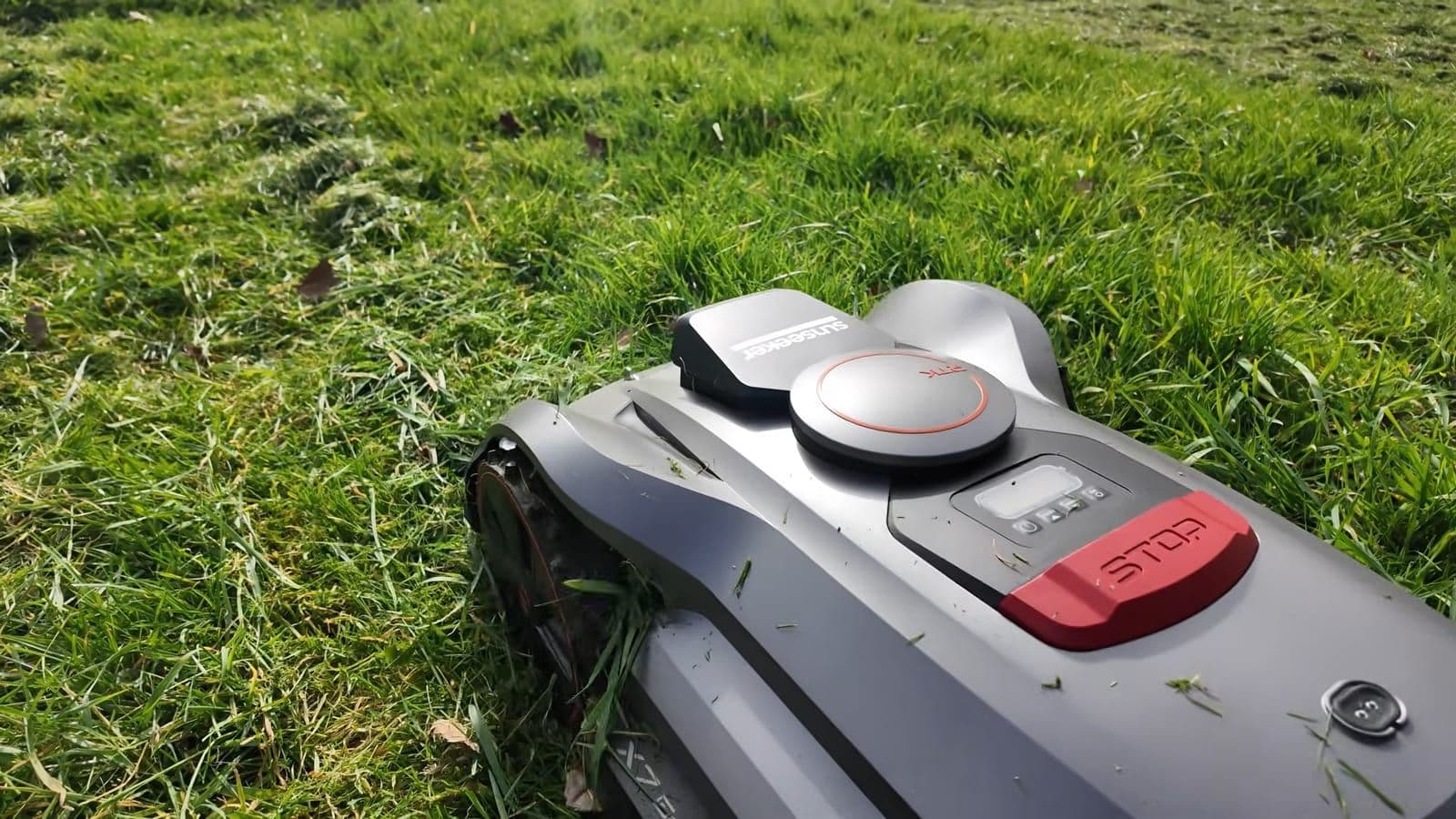 Voorkant van de Sunseeker robotmaaier terwijl hij door dicht hoog gras snijdt