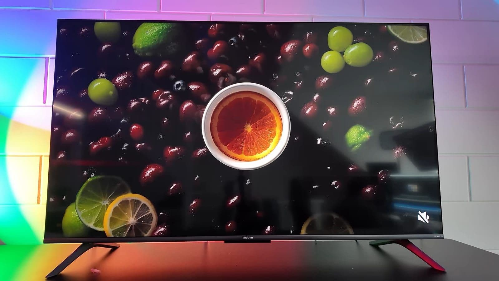 Vooraanzicht van de Xiaomi TV S Mini LED 55 met kleurrijke fruit demo op het scherm